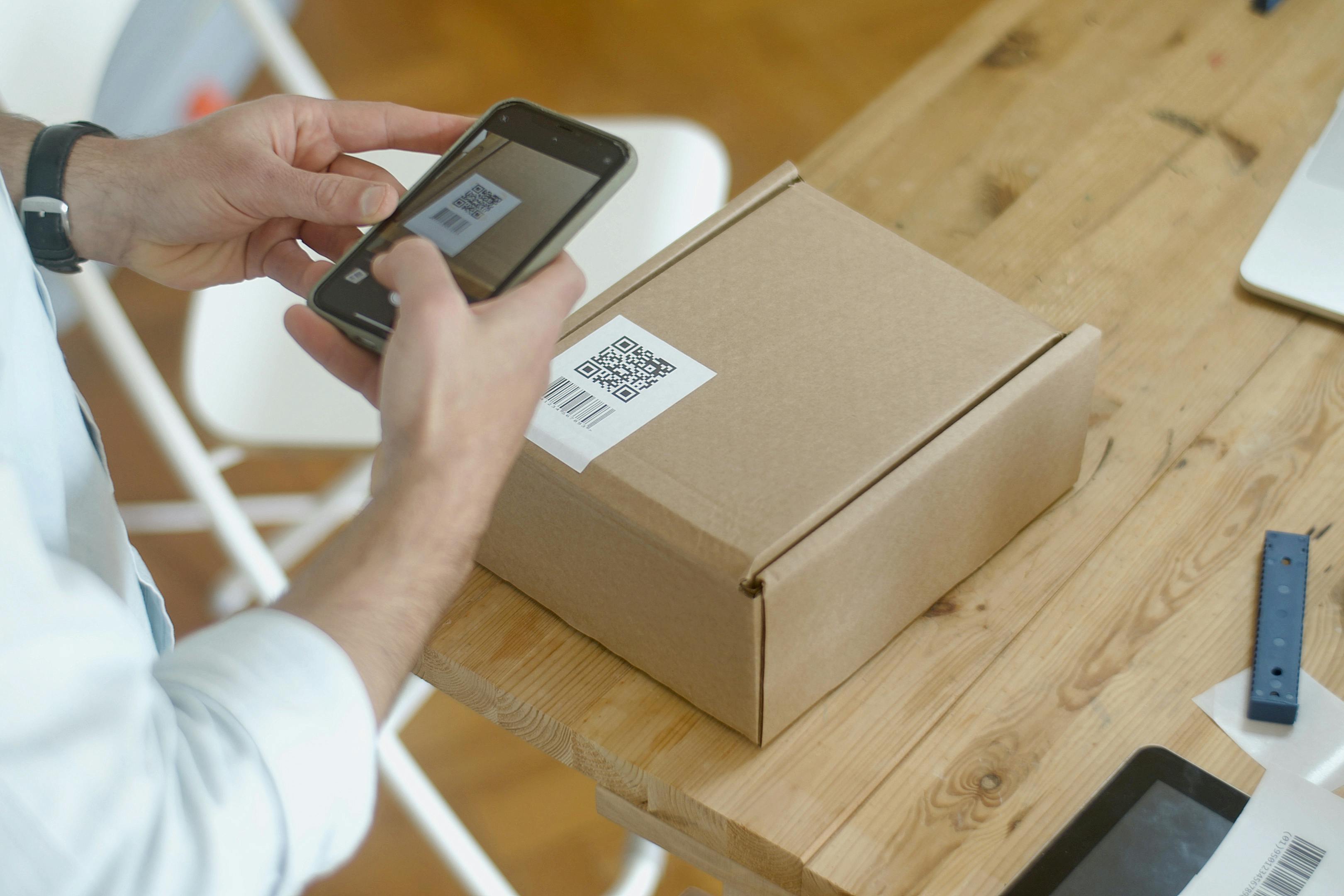 Persona escaneando con móvil un QR real adherido a una etiqueta